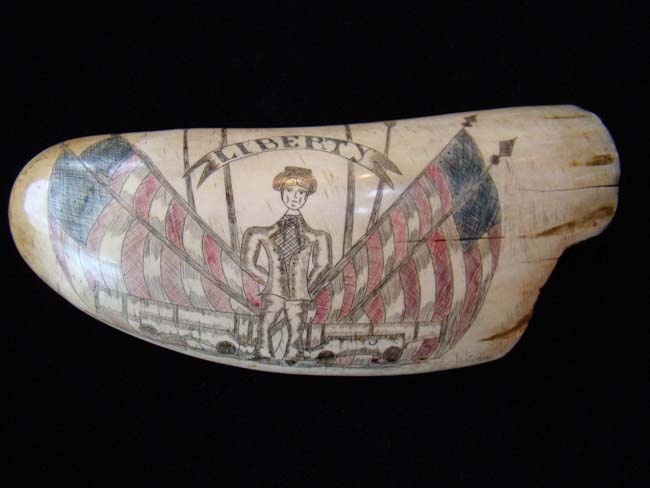 An attractive 'Liberty' themed 'sag harbor' style scrimshawed whale's tooth depicting a soldier flanked by a pair of cannons with four American flags in the background — image 4